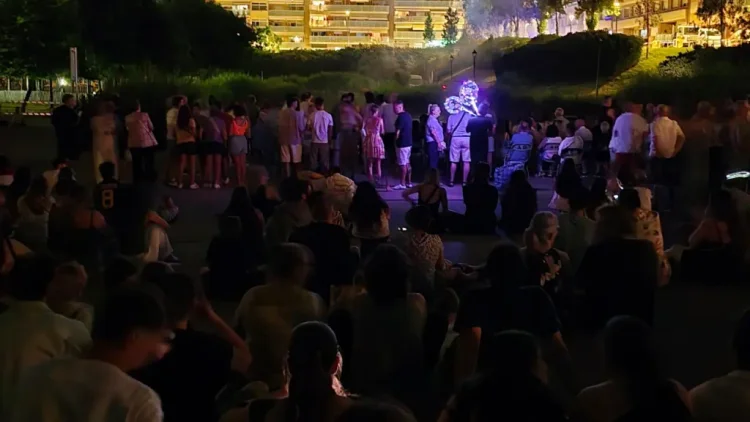Gente disfrutando del espectáculo de fin de fiestas en el parque del lago